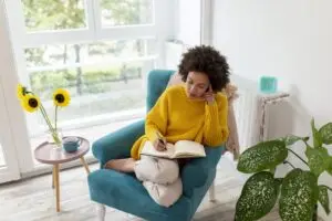 Woman writing in her mental health journal at the end of a long day