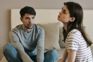 woman experiencing a bipolar episode trying to talk to her partner on the couch