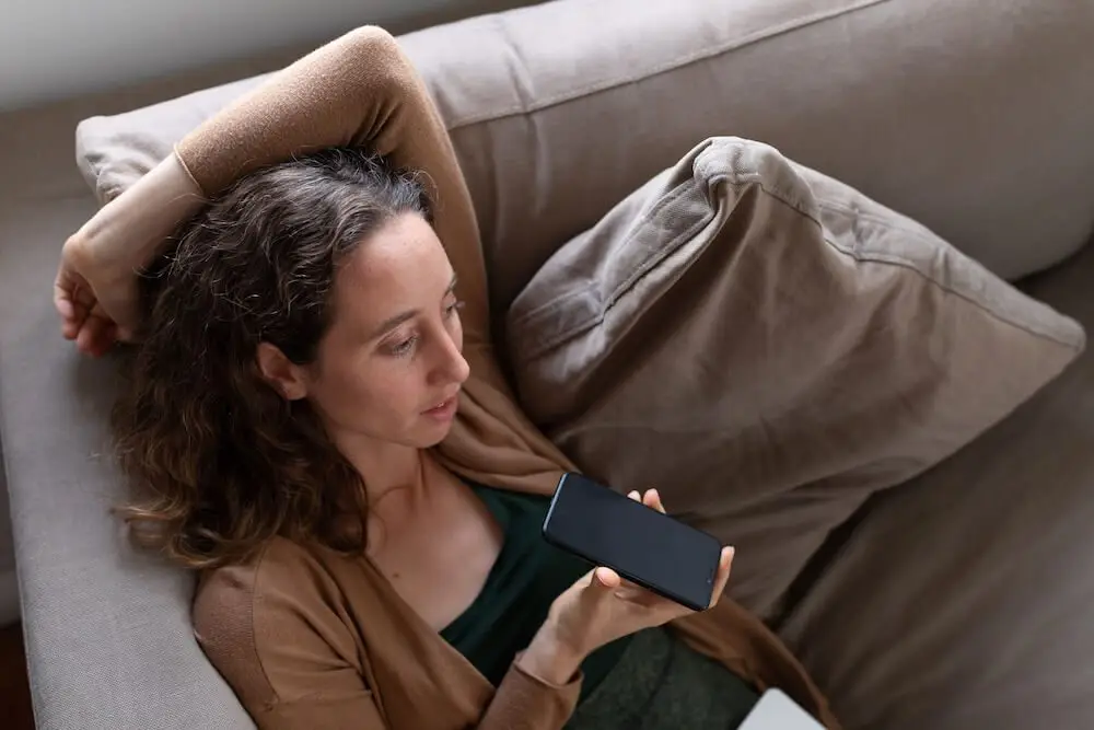 woman talking to a friend on the couch about her mental health