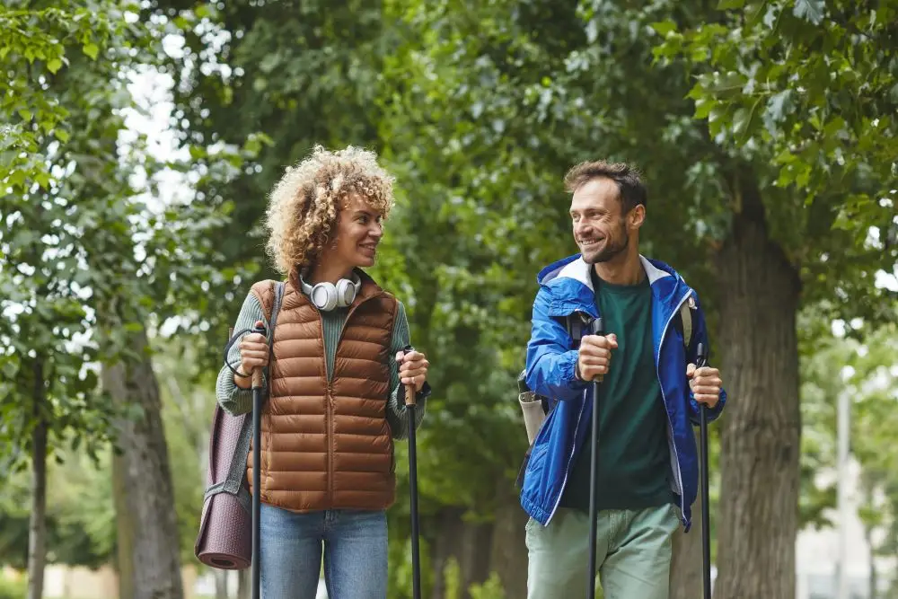 Two people hiking in a park to better their mental health and well-being.