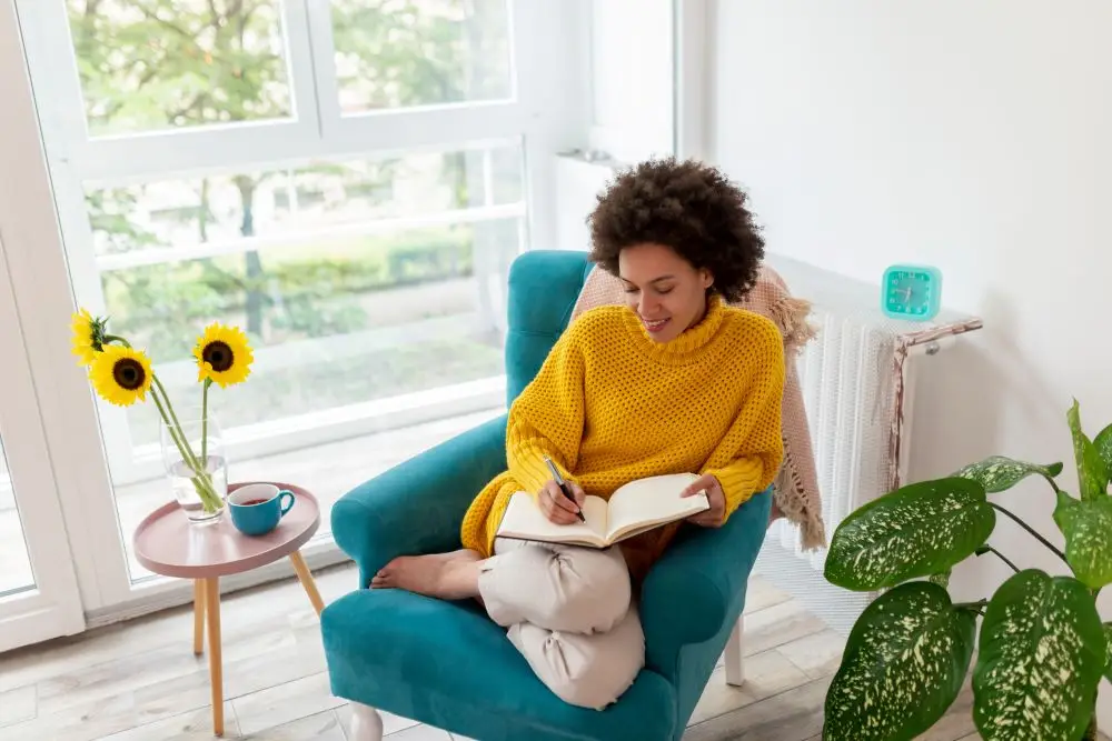 A woman writing in her journal as part of her self-care routine.