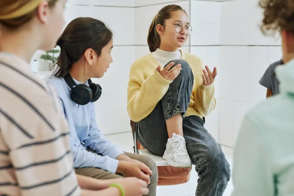 A troubled teen discussing thoughts with a support group in therapy.