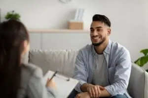 A therapist speaking to a man about goals and treatment plans during a therapy session.