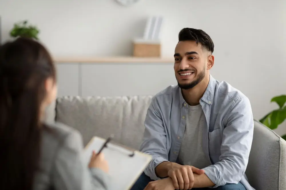 A therapist speaking to a man about goals and treatment plans during a therapy session.