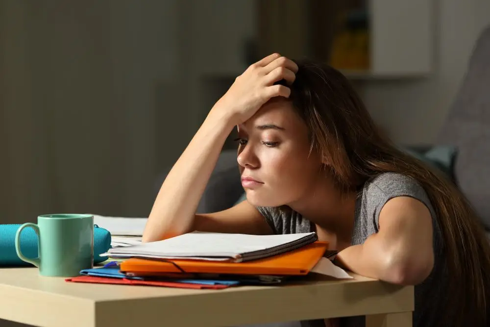 A tired college student struggling to study for her exam.