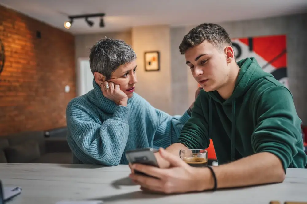 A mother speaking with her teenage song looking concerned.