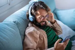 A man listening to music while scrolling on his phone.