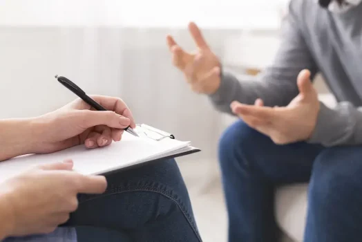 Psychotherapist writing notes, giving diagnosis to emotional man patient at counseling session, free space